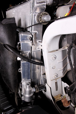 Driver's side view of our 6.7 Super Duty with Mishimoto's primary and secondary system radiators installed. The thermostat housing is pictured near the bottom.
