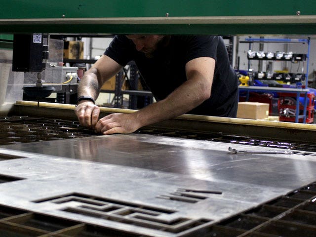 Our engineer, Mike, loads up a sheet of aluminum into our WARDJet water jet cutter