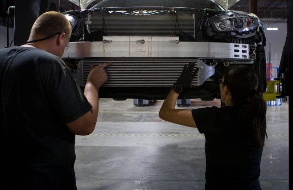 Ye, right, lends Dan a hand test fitting our intercooler sample into our loaner Si sedan.