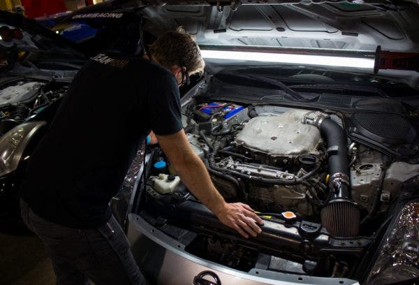 Jason inspects the engine bay of our loaner 350Z looking for the ideal location to mount our catch can.